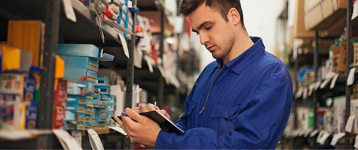 Man checks inventory in large warehouse