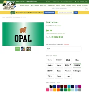 Customization page for a C&N LidSkinz product on the Everything Summer Camp website. The image shows a green trunk lid with a bear graphic and the name 'Opal' in black text, customized using the 'Athletic' font. Various font styles and colors are available for personalization.