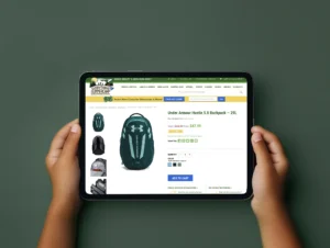 Tablet displaying a product page for an Under Armour Hustle 5.0 Backpack in a teal color on Everything Summer Camp's website, with product images and options for quantity and color selection.