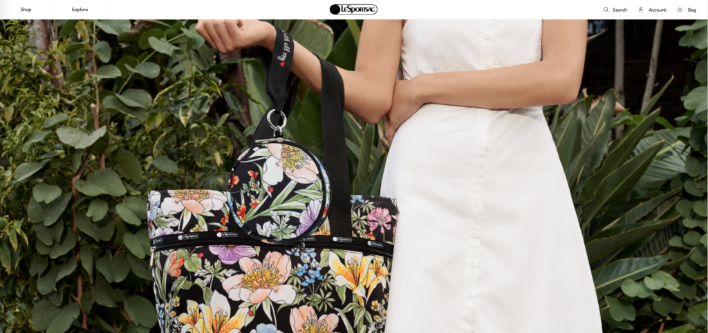 Woman in white dress holding floral-patterned bag from LeSportssac