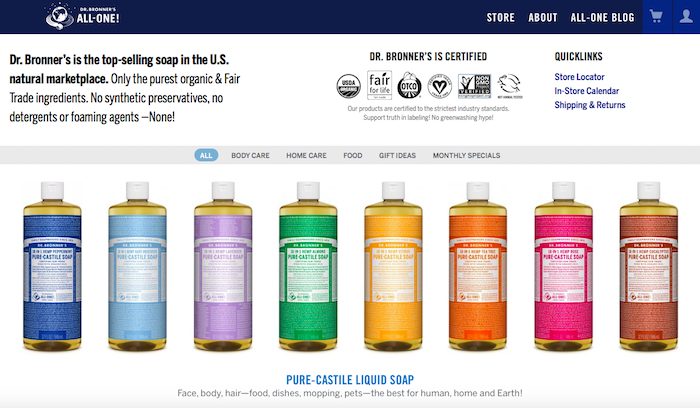 A row of large bottles of Dr Bronner's soaps. Each label is a different color and creates a rainbow across the screen